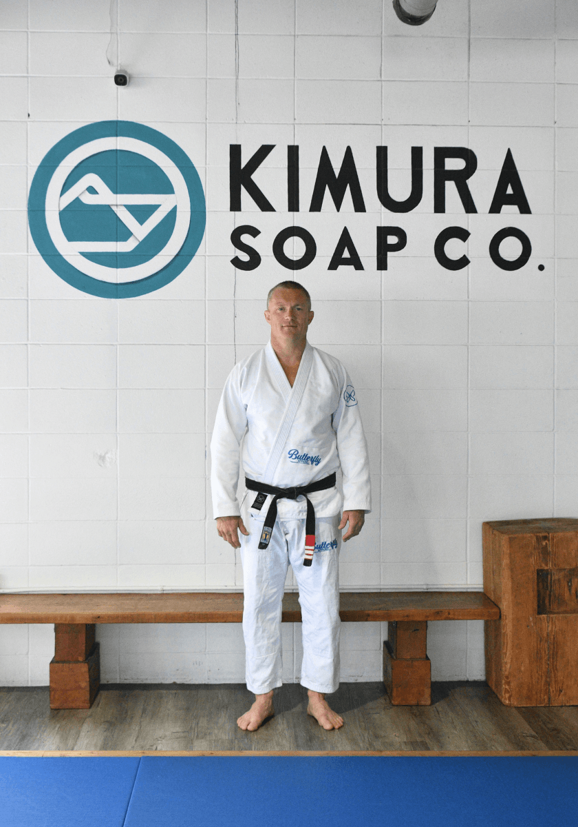 Christian standing in front of a 'Kimura Soap Co.' sign.