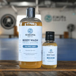 Two bottles of Kimura Soap Co. body wash on a wooden surface.