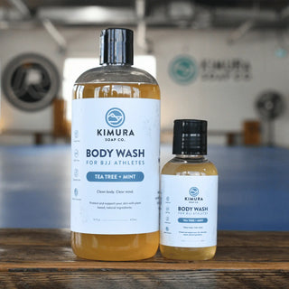 Two bottles of Kimura Soap Co. body wash on a wooden surface.